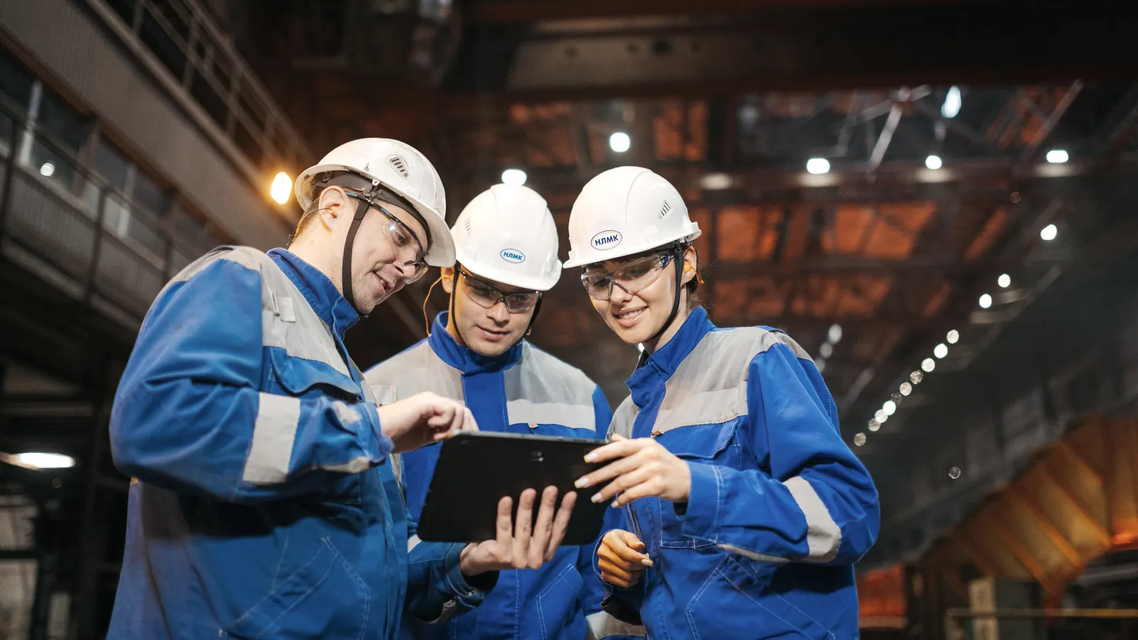 Manufacturing engineers reviewing production information on a tablet in a factory